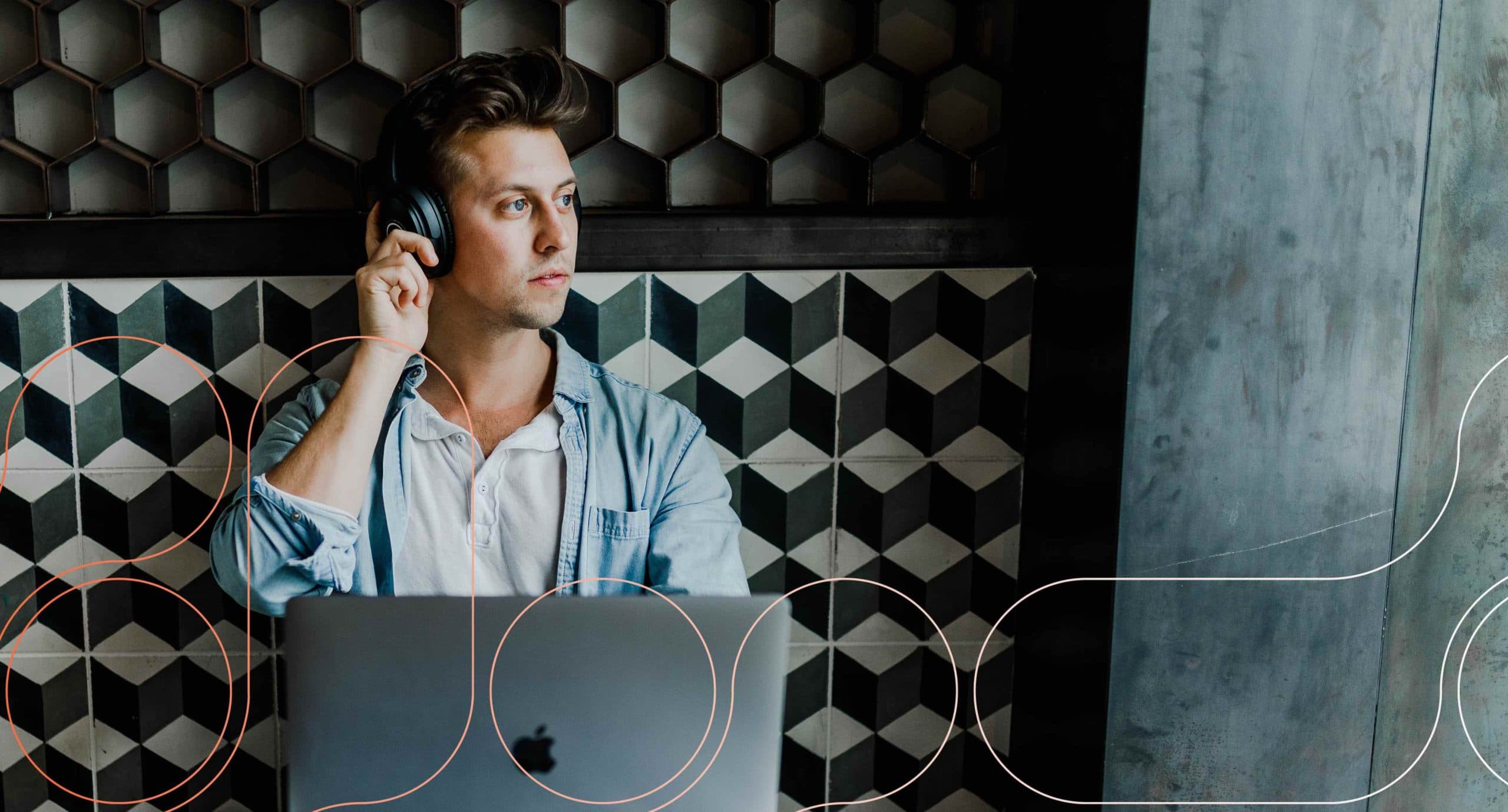 Photograph of a person sitting at a café, gancing out the window with headphones on.