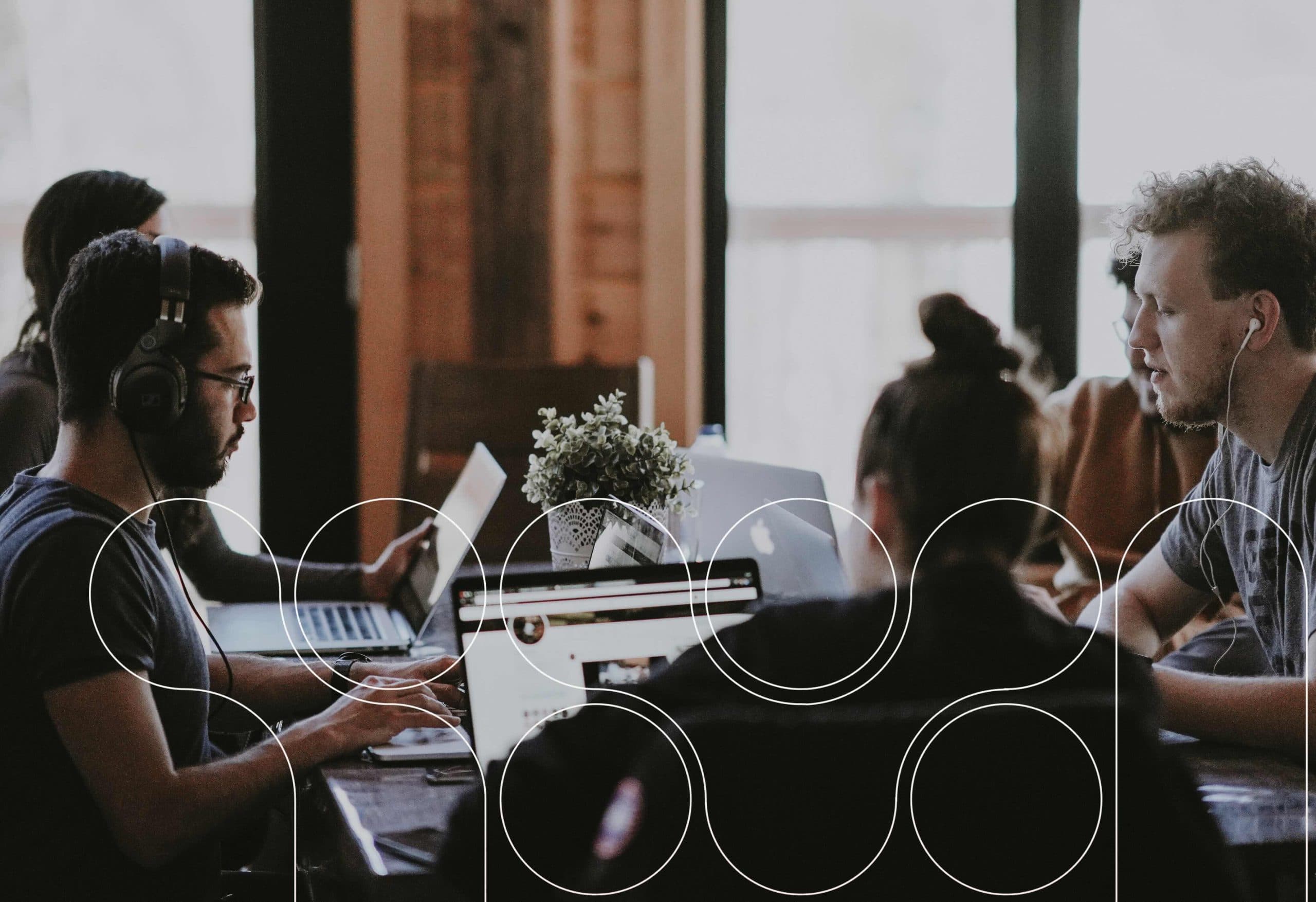 A photograph of a group of people working on their computers.